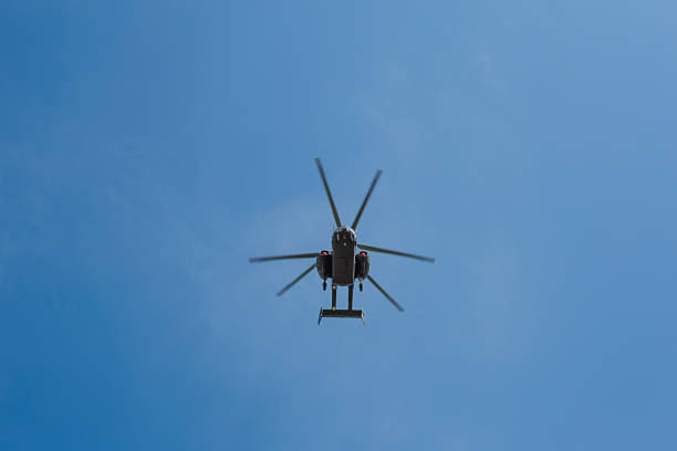 istock Small civil helicopter flies against a blue sky with clouds background 1242375274