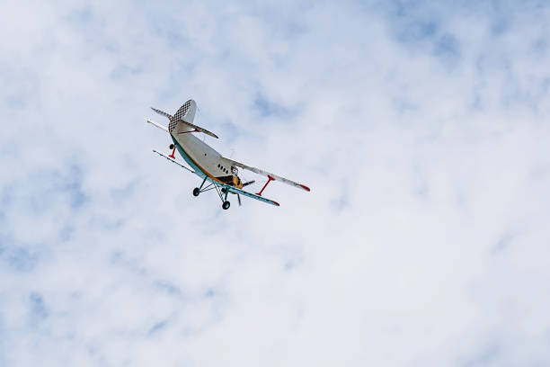 istock Small single engine vintage colorful airplane in a blue cloudy sky 1242375275