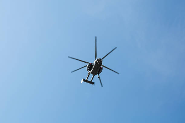 istock Small civil helicopter flies against a blue sky with clouds background 1242375790