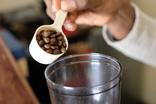How to make coffee 8: Using a measuring spoon, place the coffee beans into the coffee mill