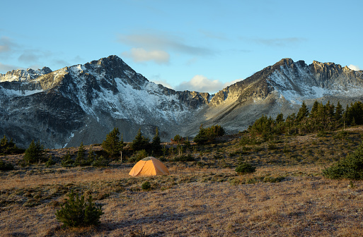 British Columbia, Canada - September 29, 2018: An early morning view of a tent below 2 mountain peaks in the Coast Mountains, British Columbia.