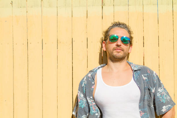 istock Man portrait possing over yellow background at Beach 1242421529