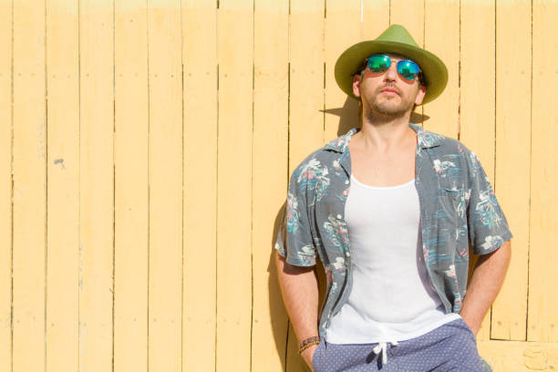 istock Man portrait possing over yellow background at Beach 1242421531