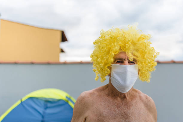 Active Senior Man having fun in night club with mask