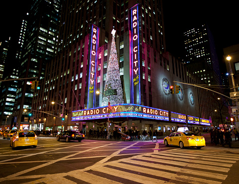 New York, NY, United States - November 6th, 2012: Radio City Music Hall, 6th av. lit up at night (contains people).