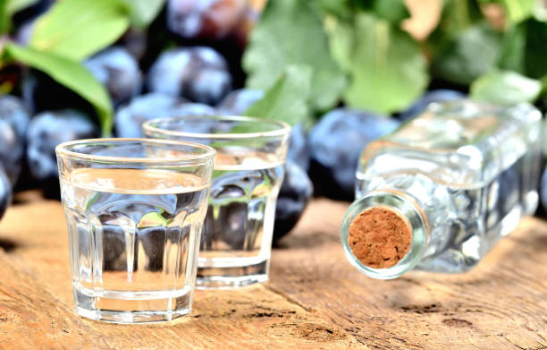 shots of slivovice and bottle on rustic wooden table - plum brandy, typical spirit from czech republic. - plum fruit organic food and drink imagens e fotografias de stock