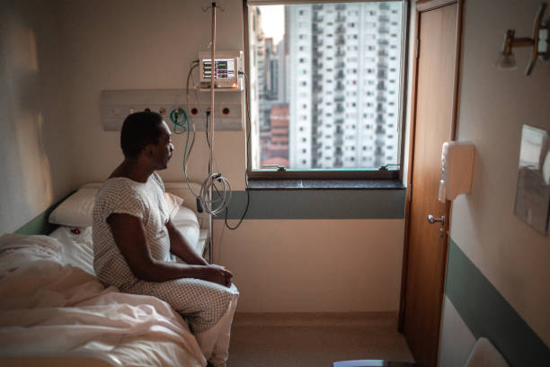 paciente sênior olhando pela janela do hospital - doença crónica - fotografias e filmes do acervo