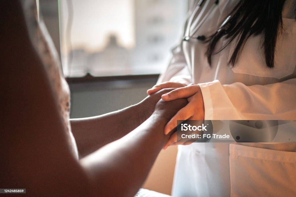 Female doctor holding hands of her patient at hospital room Doctor and patient at hospital room with face mask Healthcare And Medicine Stock Photo