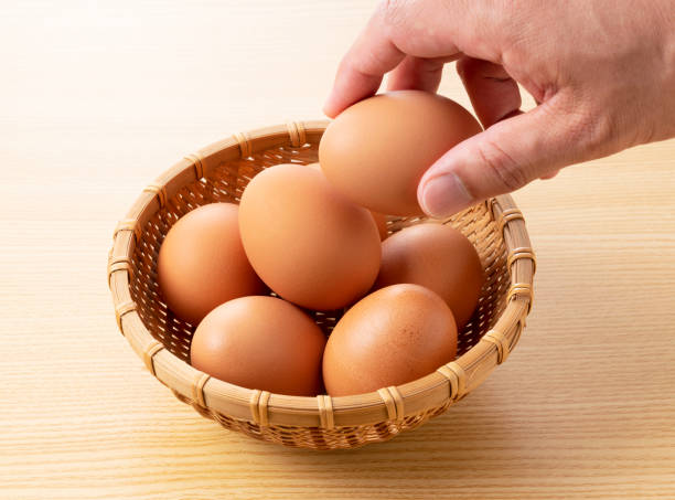 istock Eggs placed against a wooden background and held in the hand 1242500977