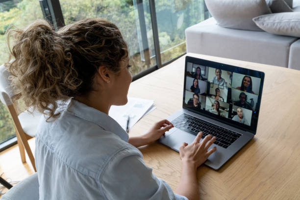 Woman in a video conference with her coworkers while working from home Woman in a video conference with her coworkers while working from home - quarantine lifestyle concepts remote control photos stock pictures, royalty-free photos & images