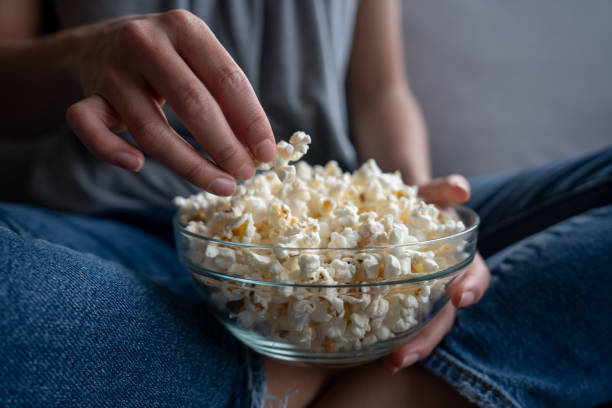 istock Close-up on a woman at home eating pop corn 1242508981