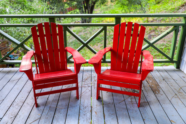 istock Red adirondack chairs on a porch in the woods 1242519366