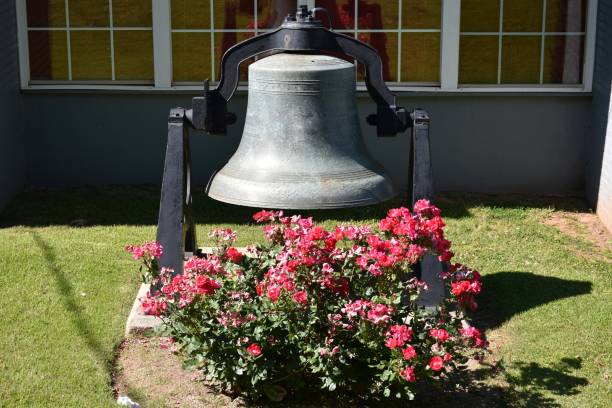 Old steel bell and flowers in front lawn