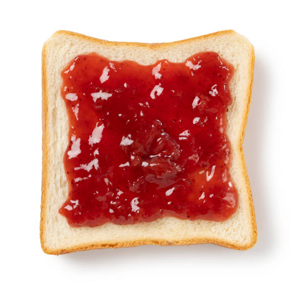istock bread spread with strawberry jam on the white background 1242602428