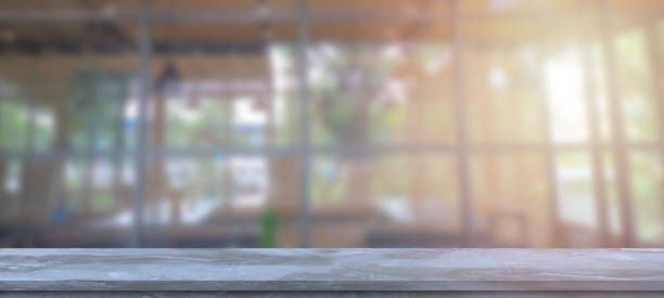 istock Empty gray cement table and blur glass wall background. 1242616910