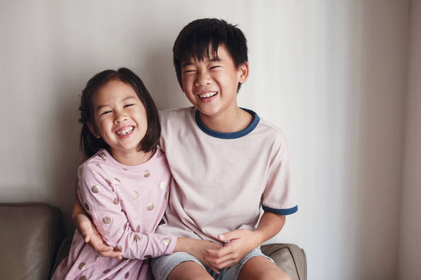 laughing asian little brother and sister at home , happy children portrait - family child portrait little girls imagens e fotografias de stock