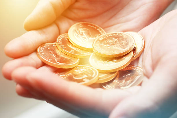 Close-up on handful of gold bullion coins.