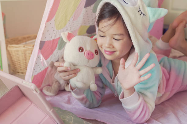 istock Mixed race Asian girl making facetime video calling with tablet at home, using zoom learning online app, social distancing, isolation, homeschooling education, learning remotely concept 1242722425