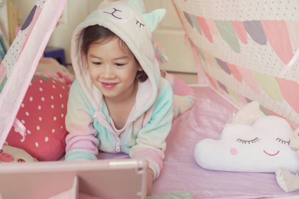 istock Mixed race Asian girl making facetime video calling with tablet at home, using zoom learning online app, social distancing, isolation, homeschooling education, learning remotely concept 1242722936