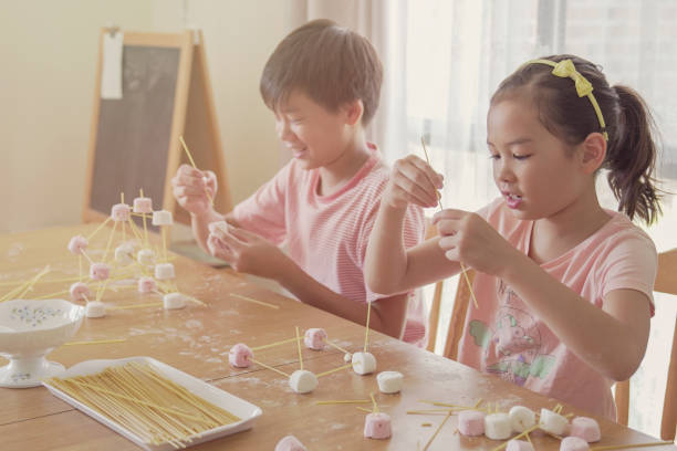 istock Mixed race young Asian children building tower with spaghetti and marshmallow learning remotely at home, STEM science, homeschooling education, Social distancing, isolation concept 1242723980