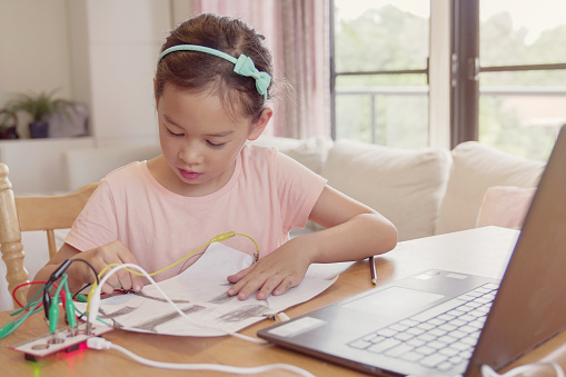 Mixed race young Asian girl learning coding together, kid learning remotely at home, STEM science, homeschooling education, Social distancing, isolation concept