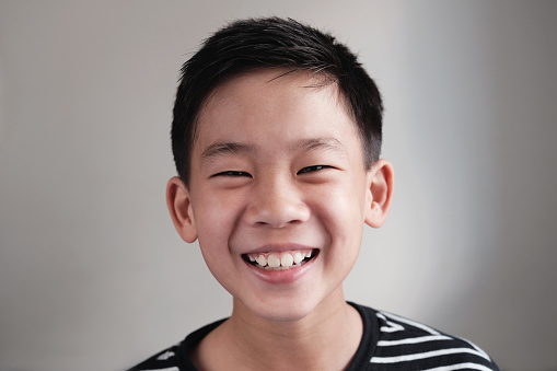 Portrait of happy, confident and healthy mixed Asian preteen teenage boy smiling