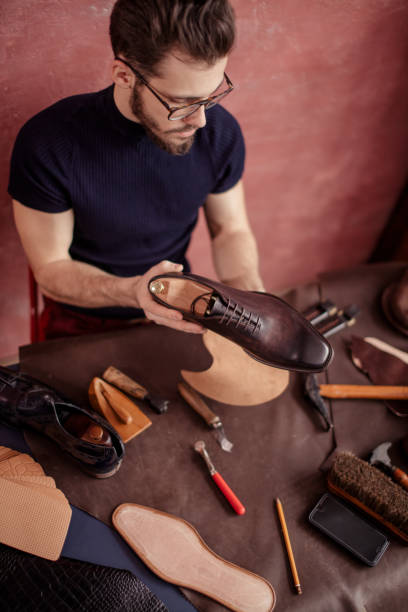 istock man specializing in creating shoes and boots 1242763047