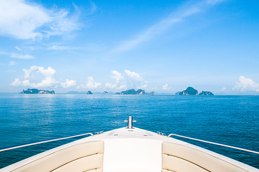 Tropical islands and wide Andaman sea view in front of white boat. Phuket vacation island trip under blue sky