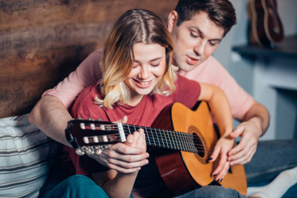istock Nice couple resting at home and playing guitar 1242791225