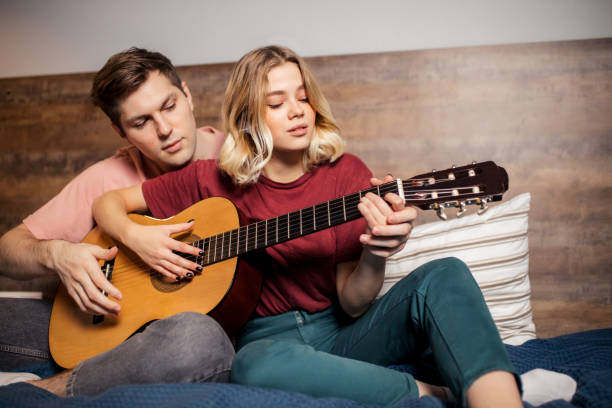 istock Nice couple resting at home and playing guitar 1242800938