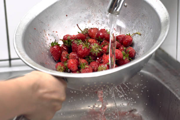 waschen von frischen rohen erdbeeren - washing fruit preparing food strawberry stock-fotos und bilder