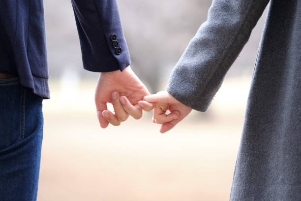 un uomo e una donna giapponesi che si tengono per mano in un parco in inverno - obscured face immagine foto e immagini stock