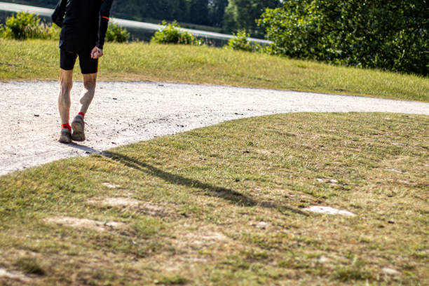 istock old man jogging on a walkay in a park, shadow by moring sun, dry ground 1242831721