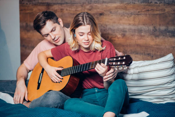 istock young couple relaxing at home playing guitar 1242854349