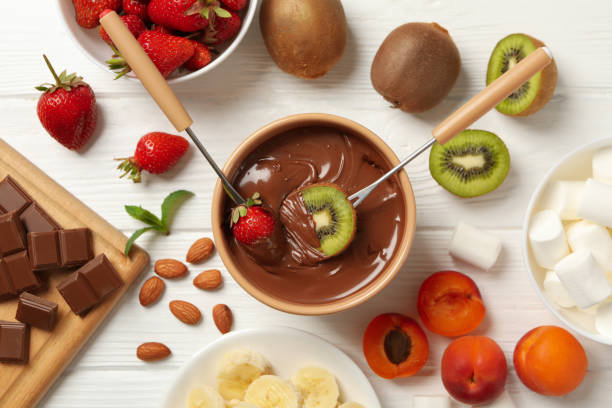composition avec ingrédients pour fondue au chocolat sur fond de bois blanc. fondue de cuisson - fondue fork photos et images de collection