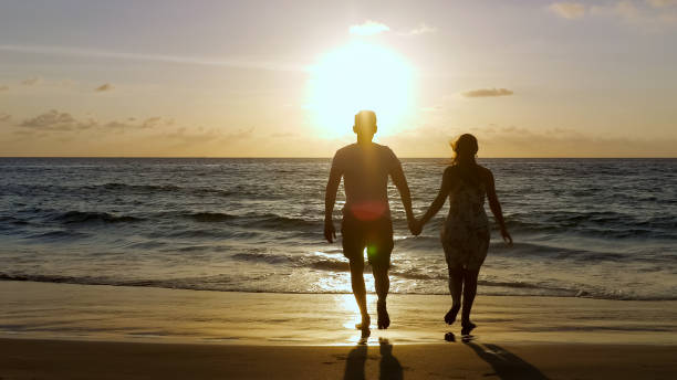 istock young family running along beach to ocean 1242930652