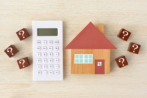 Miniature house on the calculator.Mortgage Concept.
