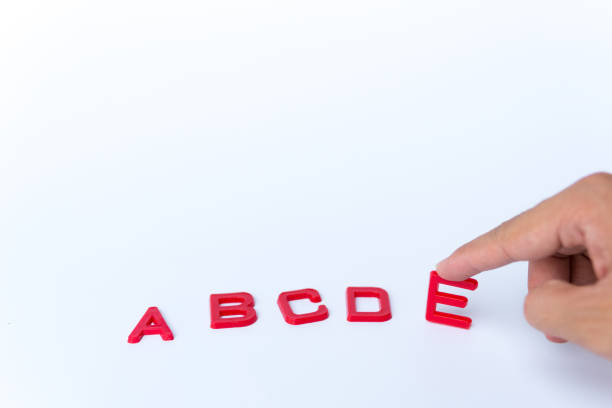 istock Red English alphabet on a white background with the hand touching the letter E 1242944841