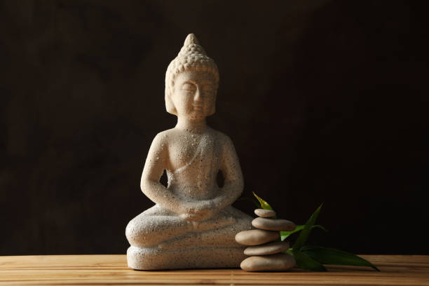 istock Buddha and stones on bamboo background. Zen concept 1242947529