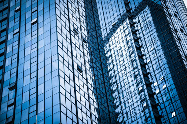 istock Modern glass building reflecting skyscrapers 1242959419