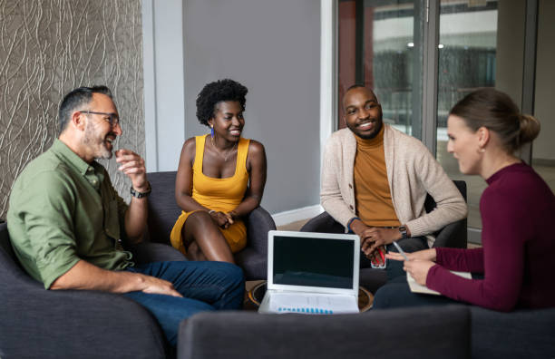 istock Smiling group of diverse businesspeople talking together during 1242975174