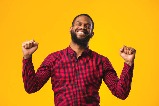 istock Happy black man triumphing with raised hands 1242983777
