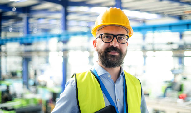 istock Front view of technician or engineer with hard hat standing in industrial factory. 1243004765