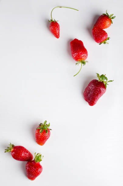 istock Vertical image.Topv iew of set of fresh delicious strawberries on the white surface.Empty space, board 1243011609