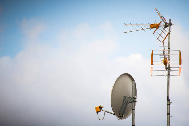 tv aerial and parabolic dish with blue sky background. - television aerial antenna television broadcasting imagens e fotografias de stock