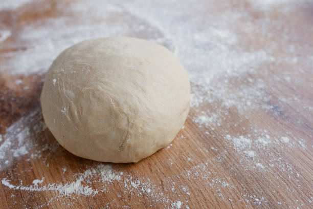 istock Ball of fresh yeast dough on floured table, resting before making pizza or bread 1243018027