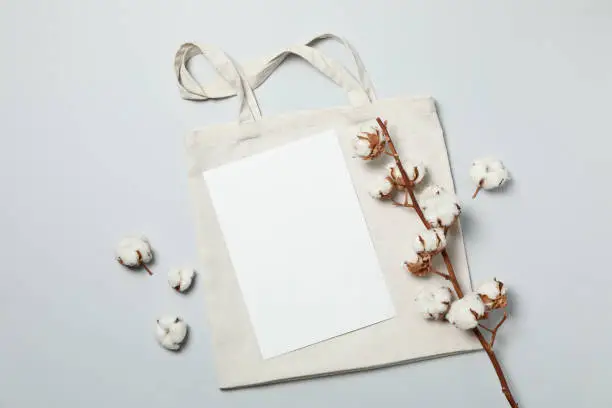 Cotton,bag and empty sheet on light gray background, space for text