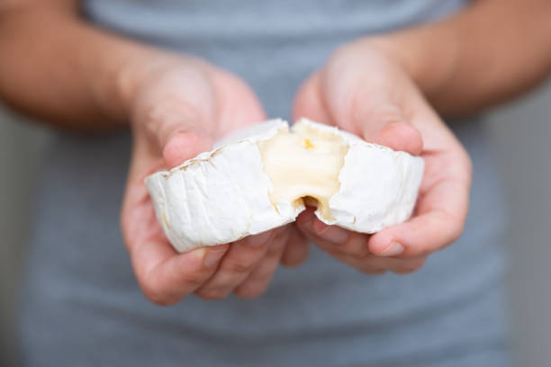 istock Hands tearing soft cheese into two parts 1243032403