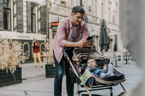 Father texting while waiting in front of the store