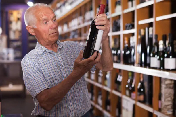 Man visiting winehouse in search of bottle of good wine